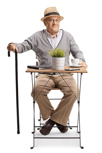 istock Elderly man sitting at a wooden coffee table 1372487411