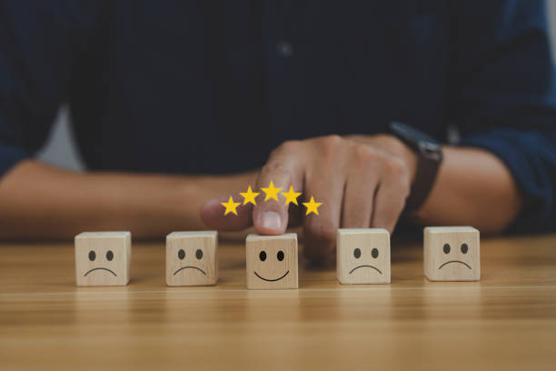 istock Satisfaction concept. businessman choose smiley face icon on wooden cube 1372489746