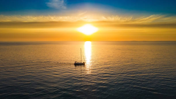 istock Yacht sails to the horizon in the setting sun 1372494128