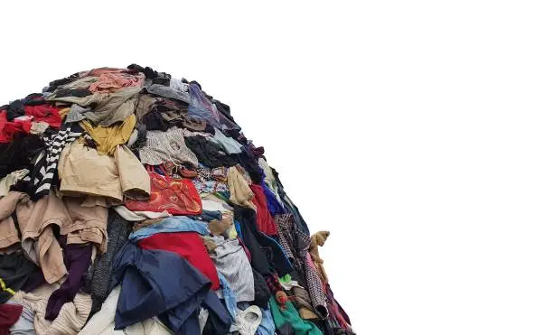 large pile stack of textile fabric clothes and shoes. concept of recycling, up cycling, awareness to global climate change, fashion industry pollution, sustainability, reuse of garment.