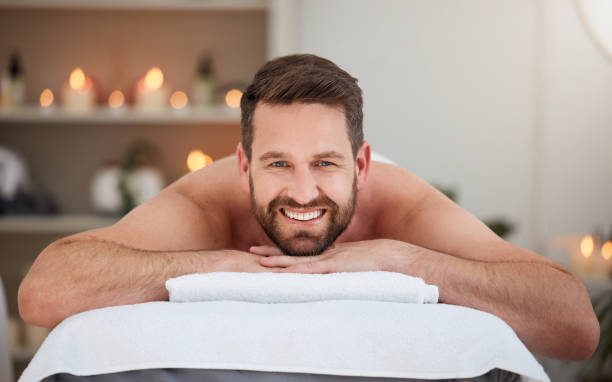 scatto di un maschio che si rilassa su un letto in una spa - vitality luxury smiling household equipment foto e immagini stock