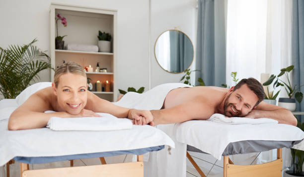 zdjęcie pary cieszącej się dniem w spa - spa treatment health spa massaging couple zdjęcia i obrazy z banku zdjęć