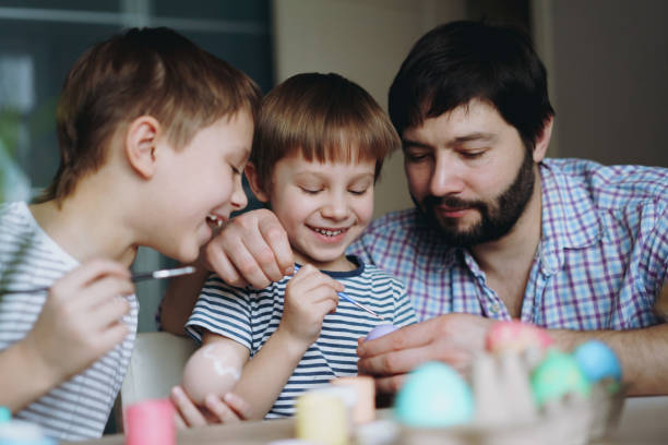 istock father and kids painting eggs for easter 1372500012
