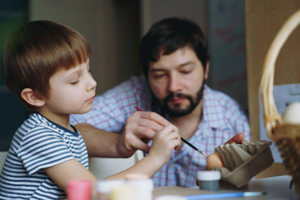 istock father and kid painting eggs for easter 1372500434