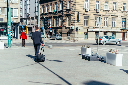 Young businessman walking with travel bag in the city