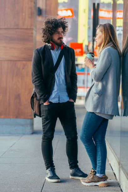 istock College student flirting with his female friend at university while leaning on a wall 1372502040