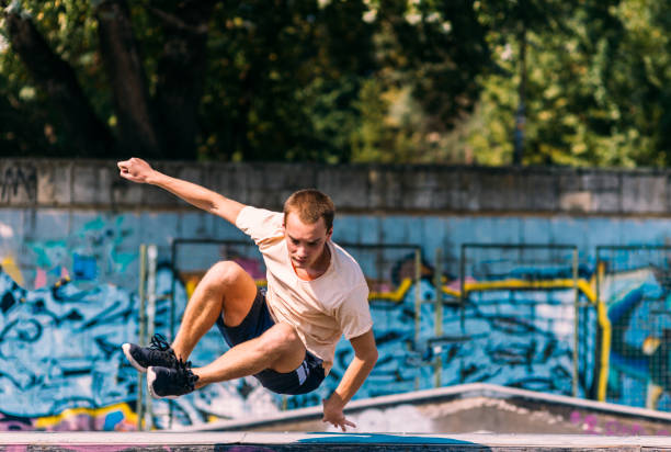 istock Sportive man running through obstacles in skatepark 1372503749