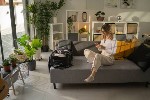 istock Woman packing for a trip and using phone 1372505526