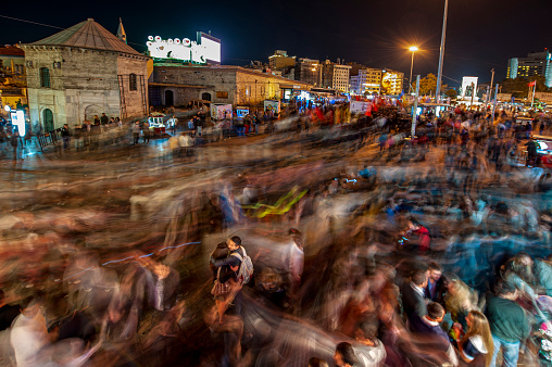 Istanbul, Turkey - October 2, 2010: At night, Beyoğlu in Taksim is among the places where tourists and locals walk in groups and shop. The movement of this crowd was captured with a long exposure.