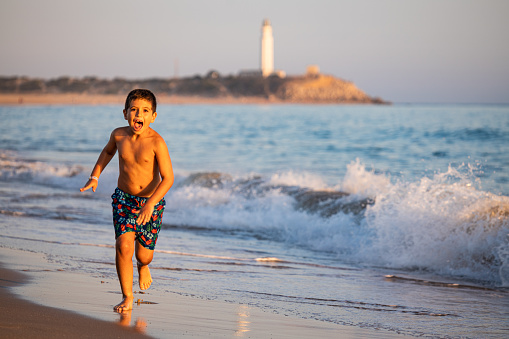 Children run along beach.