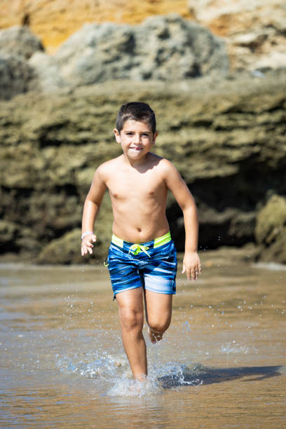istock Little kid running on a rocky beach 1372506060