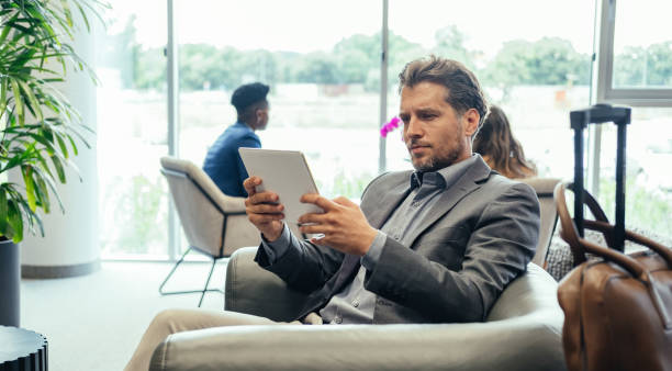 istock Handsome Businessman Using Digital Tablet While Waiting for his Flight in the Business Lounge 1372506150