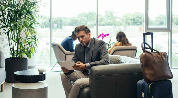 istock Handsome Businessman Using Digital Tablet While Waiting for his Flight in the Business Lounge 1372506151