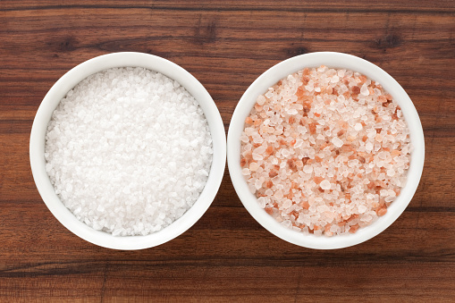 Top view of two bowls side by side with regular and himalayan rock salt
