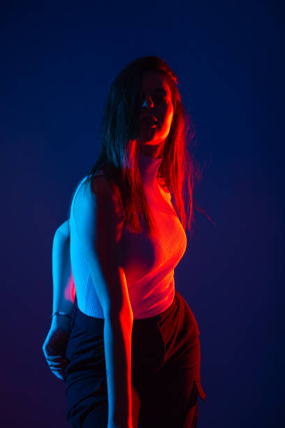 istock Female model posing in studio with red and blue colors at high contrast. 1372509765