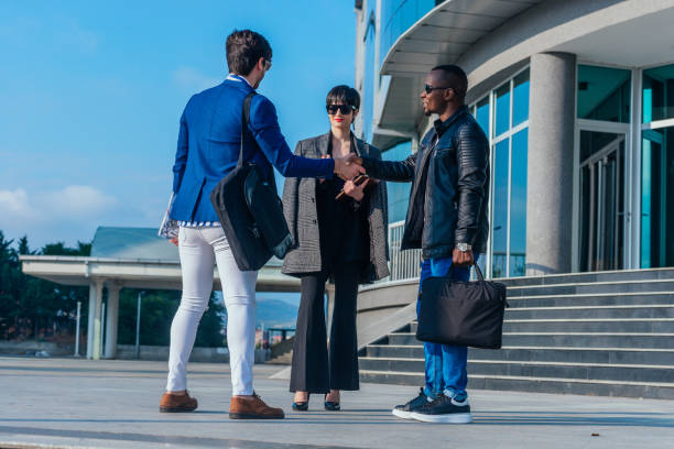 istock Business partners greeting one another by shaking hands outside workplace 1372512347