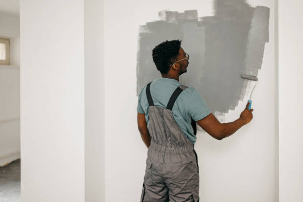 istock African-American professional painter paints the wall indoors 1372512708