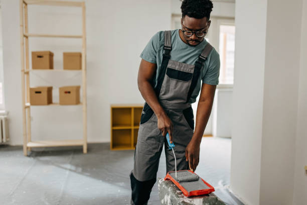 istock African-American professional painter paints the wall indoors 1372512718