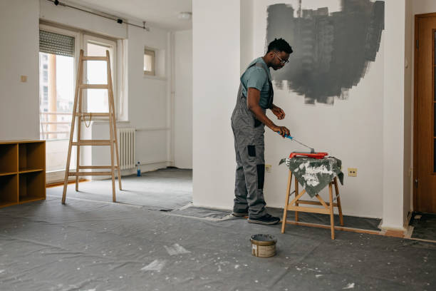 istock African-American professional painter paints the wall indoors 1372512766