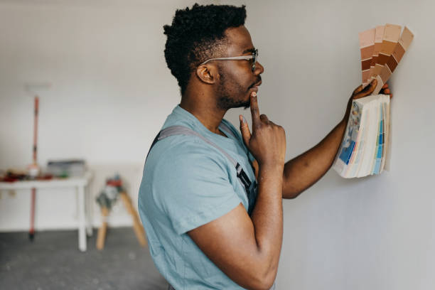 istock African-American professional painter paints the wall indoors 1372512796