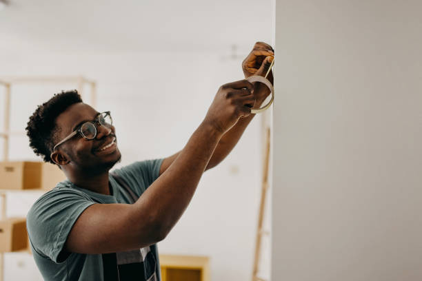 афро-американский профессиональный художник красит стену в помещении - house painter home improvement professional occupation occupation стоковые фото и изображения