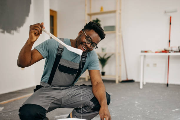 istock African-American professional painter paints the wall indoors 1372512820