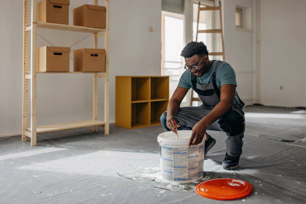 African-American professional painter paints the wall indoors