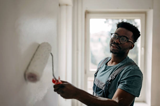 istock African-American professional painter paints the wall indoors 1372512948