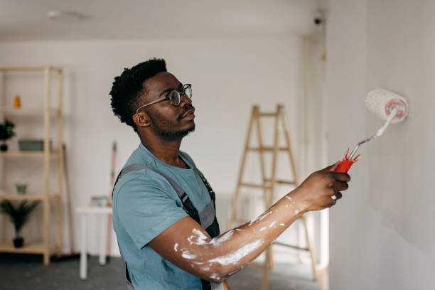 istock African-American professional painter paints the wall indoors 1372512964