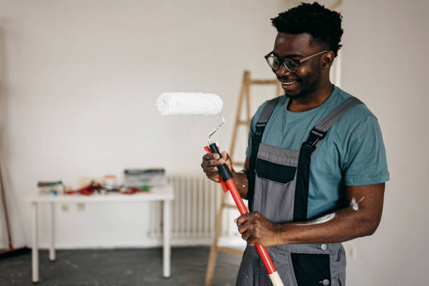 istock African-American professional painter paints the wall indoors 1372512996