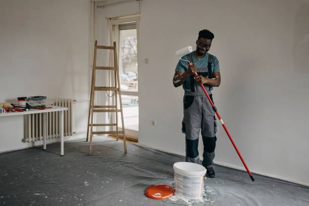 istock African-American professional painter paints the wall indoors 1372513003
