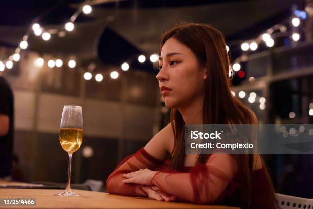 Young Asian Woman Feeling Sad And Heartbroken After Breaking Up With Her Boyfriend While Sitting At Restaurant Stock Photo - Download Image Now