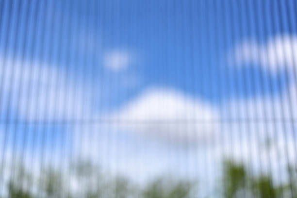 blurry view blue sky with cloud through soft white curtain from bedroom. abstract  blue sky with cloud blurry bakground. Out of focus background - nature shadow of green trees
