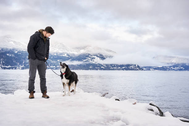 istock Dog and his owner standing by ocean during a winter walk 1372522150