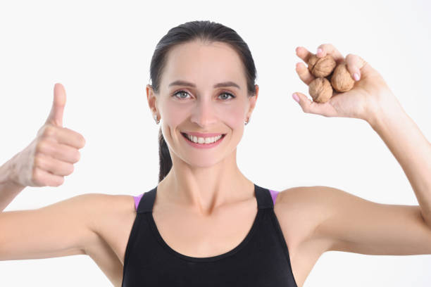 istock A beautiful sportswoman holds walnuts in her hands 1372522617