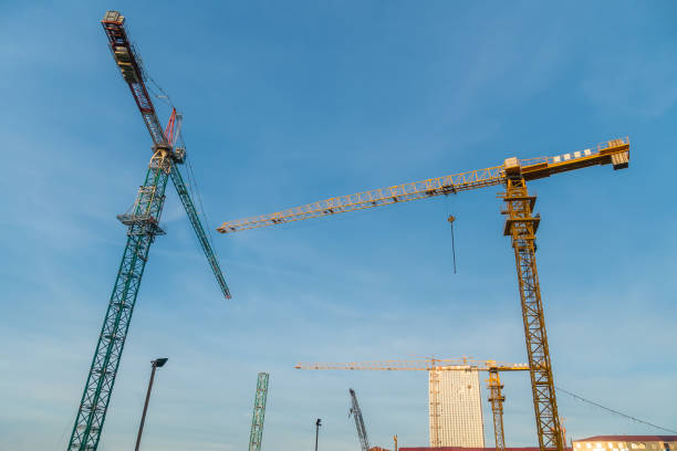 istock Construction cranes on the background of the blue sky before sunset . Construction, industry in the city 1372524356