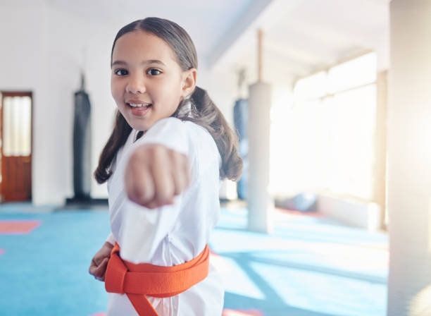 ujęcie uroczej dziewczynki ćwiczącej karate w studiu - sports activity zdjęcia i obrazy z banku zdjęć