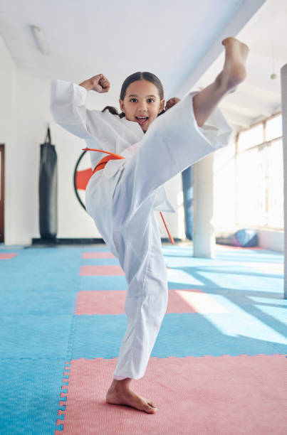 scatto di una graziosa bambina che pratica karate in uno studio - karate foto e immagini stock