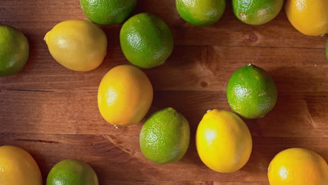 SLO MO LD Lemons and limes rolling across a table