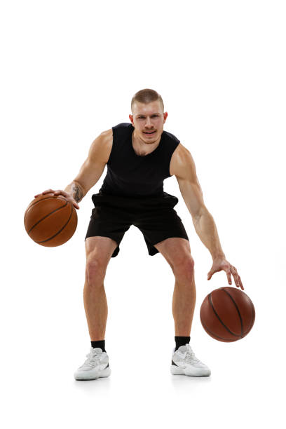 istock Handsome muscled man, basketball player posing with two balls isolated on white studio background. Sport, motion, activity concepts. 1372526786