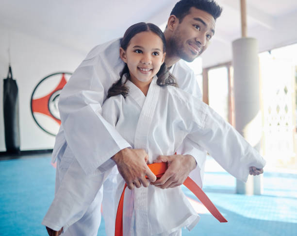 tiro de um jovem e menina bonita praticando karatê em um estúdio - karate child judo belt - fotografias e filmes do acervo