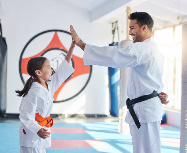 scatto di un giovane e di una bambina carina che praticano il karate in uno studio - arte marziale foto e immagini stock