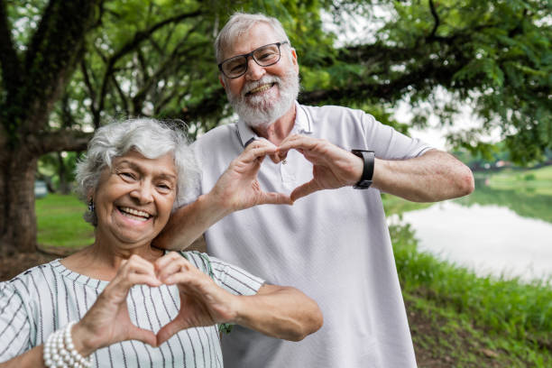 istock Senior couple making a heart symbol with their hands 1372528697