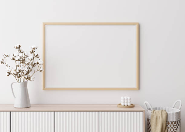 istock Empty horizontal picture frame on white wall in modern living room. Mock up interior in minimalist, contemporary style. Free space for your picture, poster. Console, cotton plant. 3D rendering. 1372528726