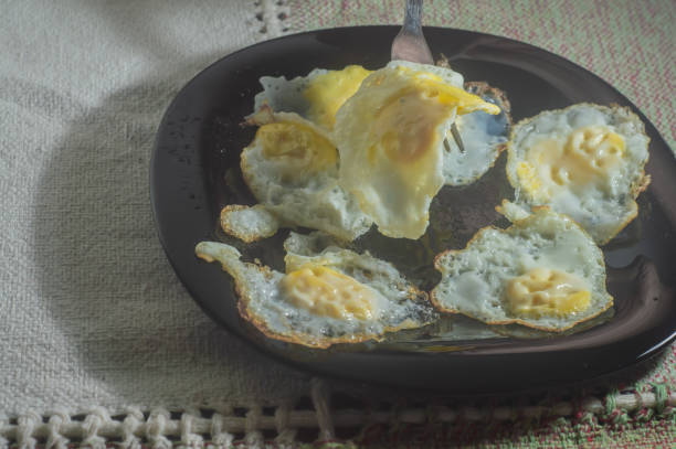 istock Fried quail eggs on a black dish with tablecloth in the background 1372529175