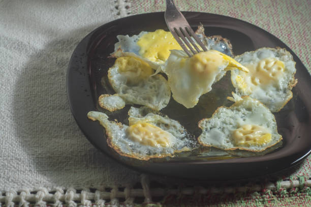 istock Fried quail eggs on a black dish with tablecloth in the background 1372529185