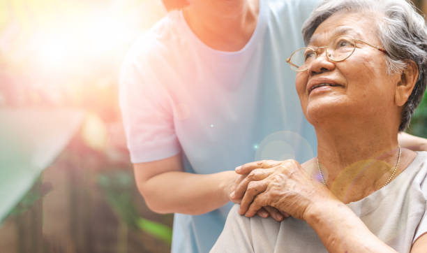 opiekun, opiekun trzymający starszą rękę w opiece hospicyjnej. filantropia życzliwość dla niepełnosprawnych koncepcji. - consoling zdjęcia i obrazy z banku zdjęć