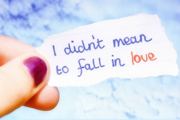 istock I didn't mean to fall in love, says torn note held up by young woman's hand 1372530627