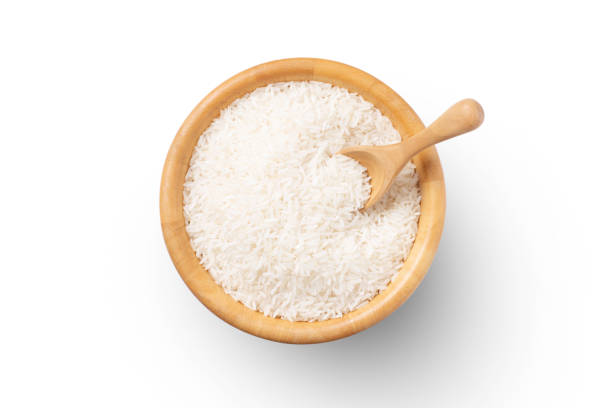 Uncooked white jasmine rice Uncooked white jasmine rice in wooden bowl and scoop isolated on white background. Top view. flat lay. jasmine rice stock pictures, royalty-free photos & images