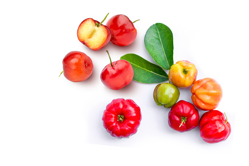 Fresh red acerola cherry fruit with cut in half sliced and green leaf isolated on white background. Top view. Flat lay.